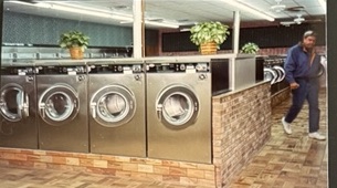 World O' Suds Coin Laundry, 430 E Main St Apopka FL — foto vintage del interior que muestra la hilera de lavadoras de la era fundadora y el mostrador de ladrillo