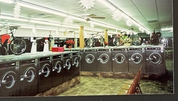 World O' Suds Coin Laundry, 430 E Main St Apopka FL — foto vintage de una larga hilera de lavadoras con bicicletas sobre la hilera de lavadoras y decoraciones navideñas de copos de nieve en el techo