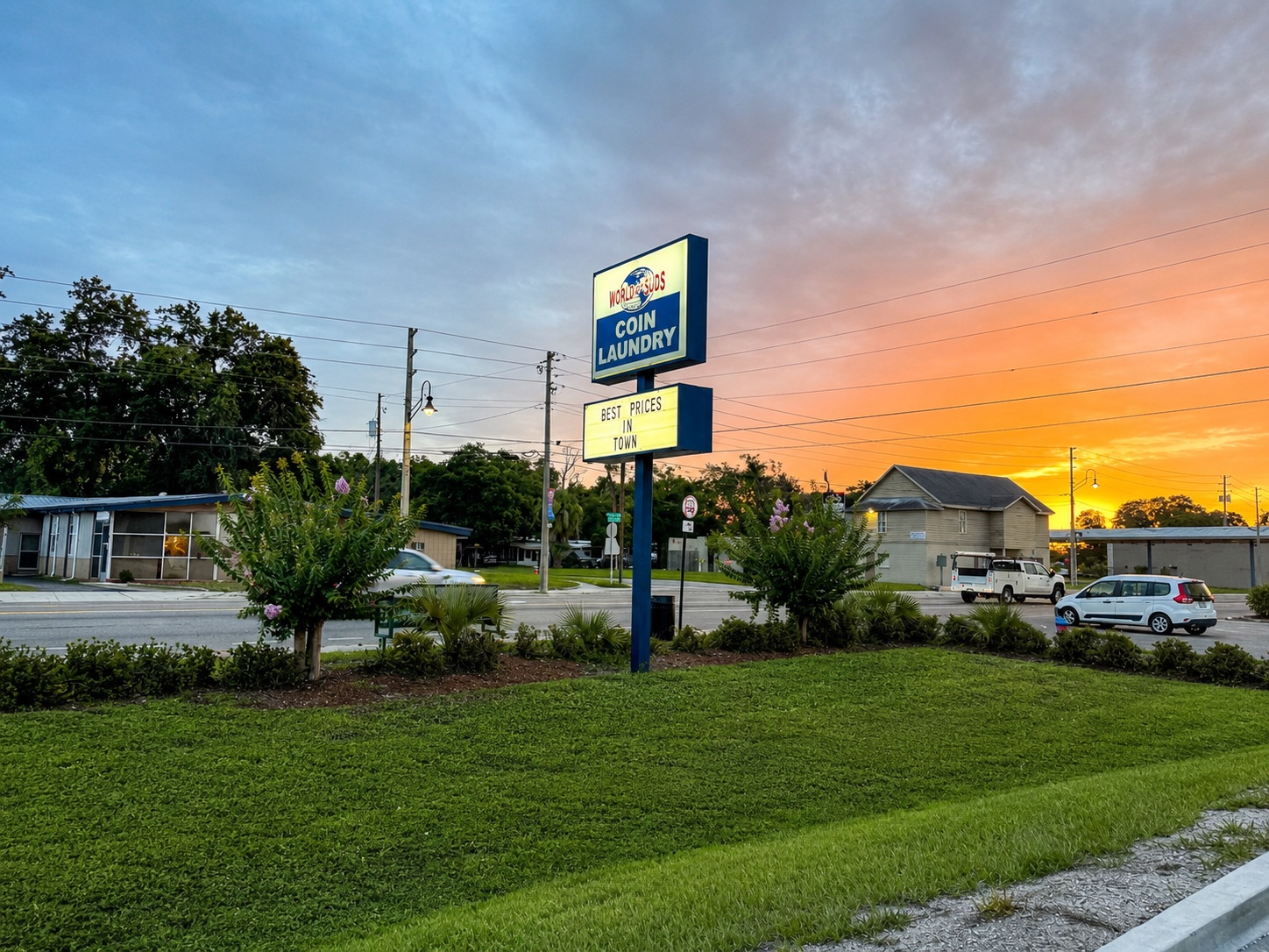 World O' Suds Coin Laundry, 430 E Main St Apopka FL — letrero de carretera en la hora dorada con el texto Best Prices in Town