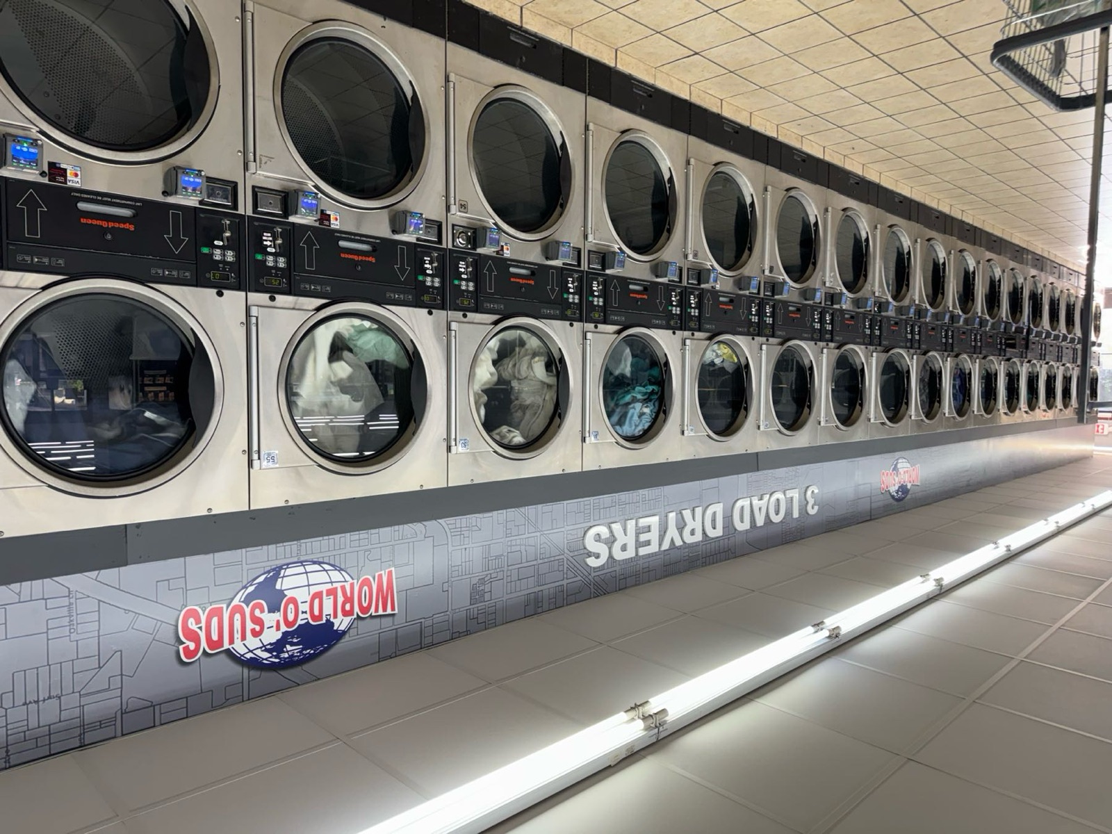 World O' Suds Coin Laundry, 430 E Main St Apopka FL — wall of 3-load commercial dryers with LED display panels