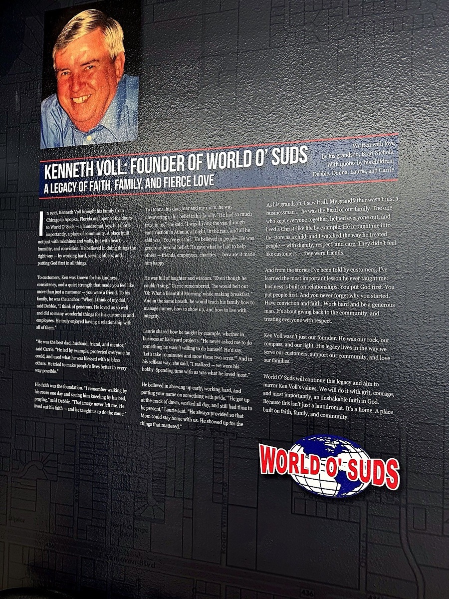 World O' Suds Coin Laundry, 430 E Main St Apopka FL — pared de homenaje al fundador Kenneth Marvin Voll, 1938-2010, con placa conmemorativa y fotografía de retrato