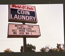 World O' Suds Coin Laundry, 430 E Main St Apopka FL — escaneo vintage de la marquesina original en Main Street, 1999, del archivo de la familia, con el texto BETTER THAN CHEESECAKE WE ARE NO 1